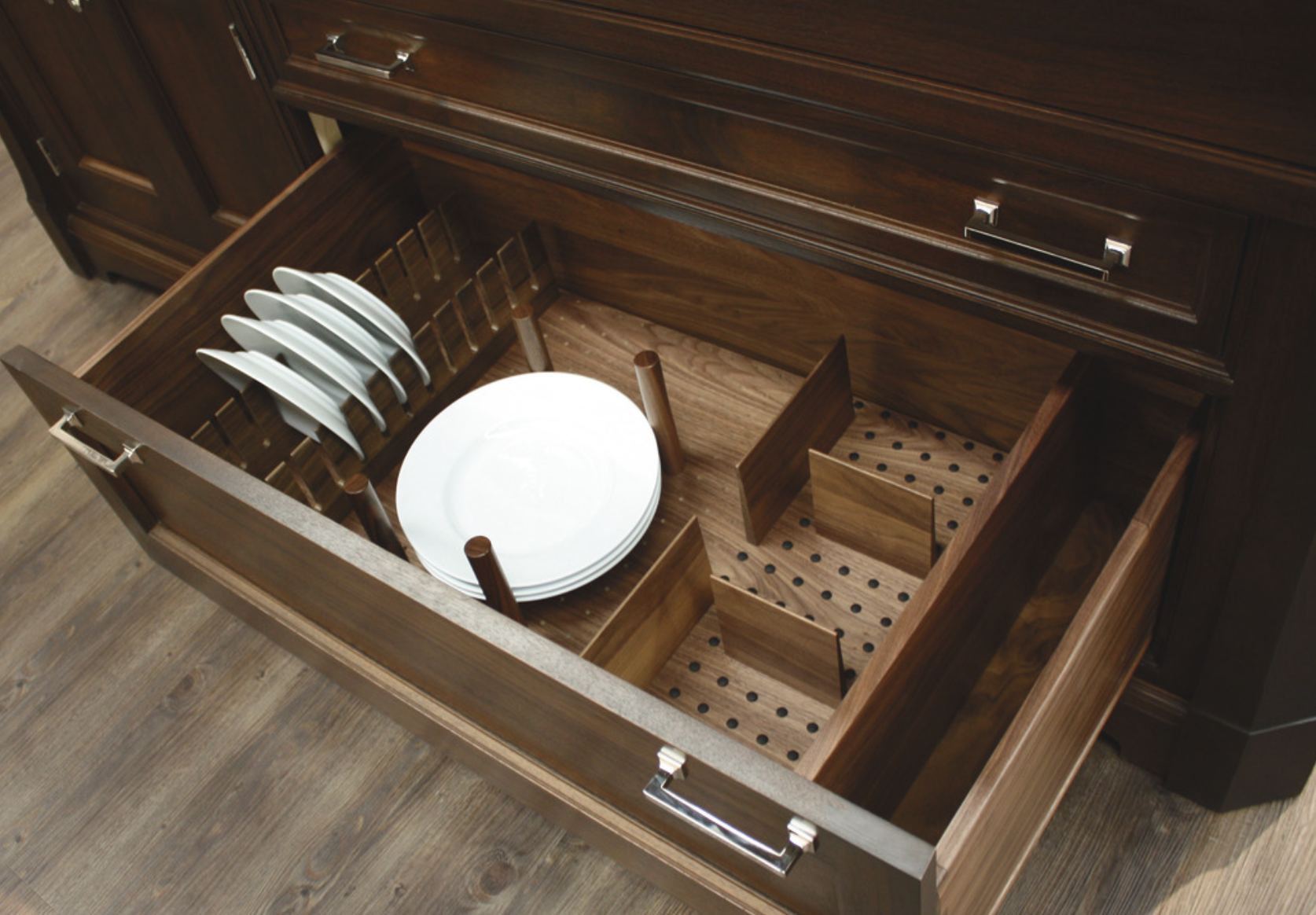Deep kitchen drawer with a pegboard insert holding dinner plates